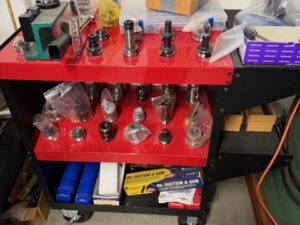 Assorted CNC toolholders arranged on a red tooling cart