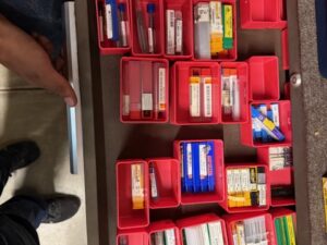 Packaged cutting tools and inserts organized in red drawer bins