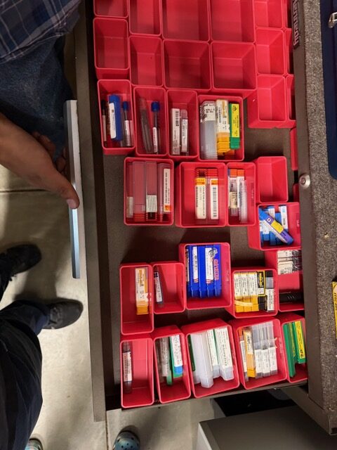 Packaged cutting tools and inserts organized in red drawer bins