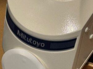 Close-up of the Mitutoyo microscope body and manufacturer badge