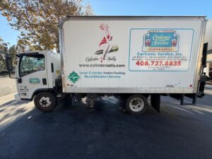 Actual 2014 Isuzu NRR diesel box truck with rear liftgate, side view