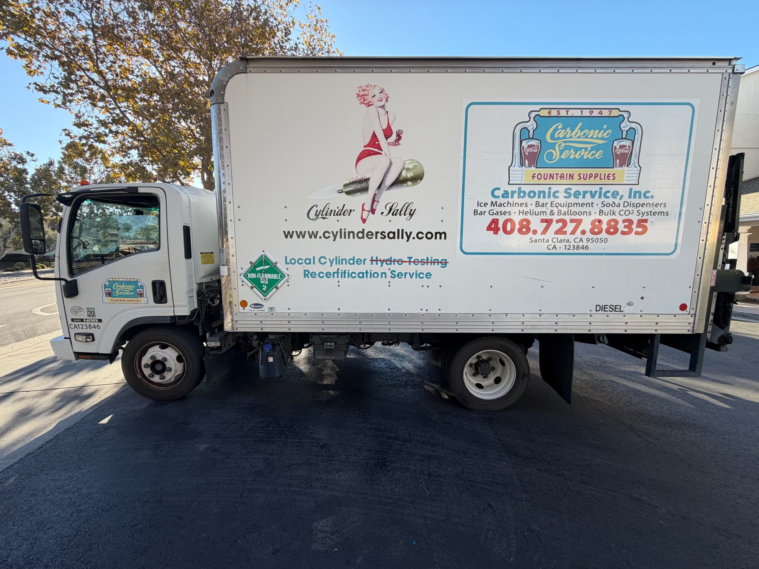 Actual 2014 Isuzu NRR diesel box truck with rear liftgate, side view